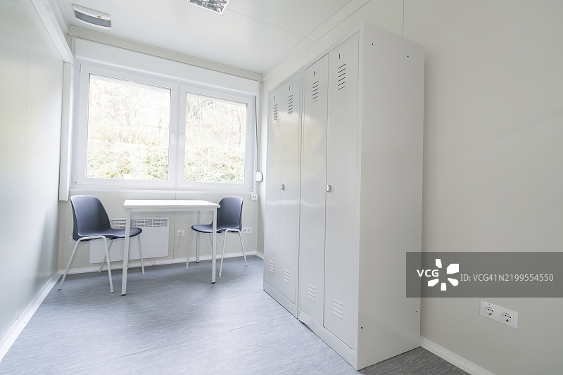简单的办公室，配有桌子、两把椅子、一个橱柜和大窗户，难民住宿地点Beermiß，Calmbach，黑森林，德国，欧洲图片素材