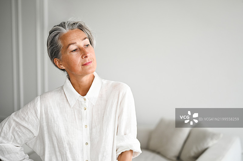 自信的成熟的女性肖像，身穿白色服装。图片素材