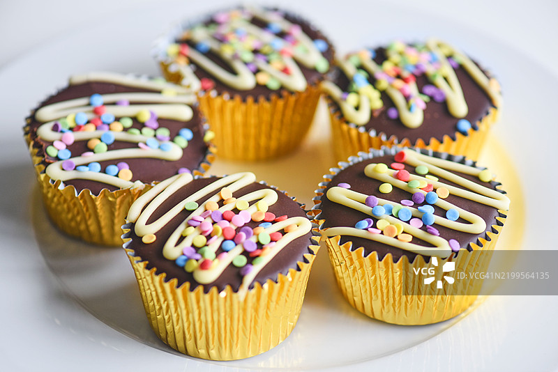 多彩鲜艳的杯子蛋糕出售。图片素材