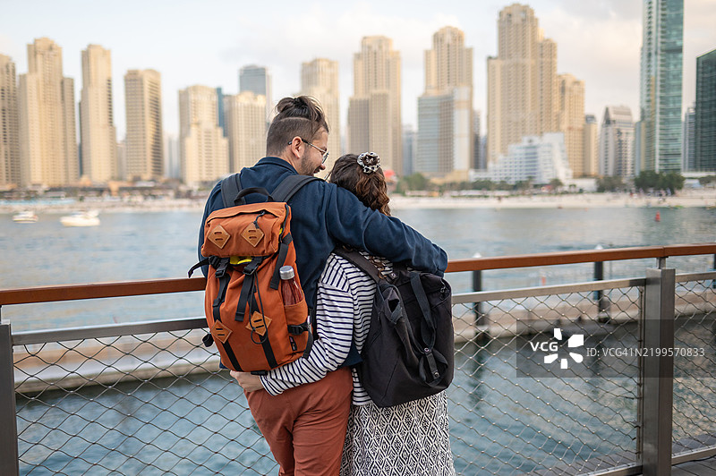 情侣在迪拜码头享受水边美景，背后是摩天大楼。图片素材