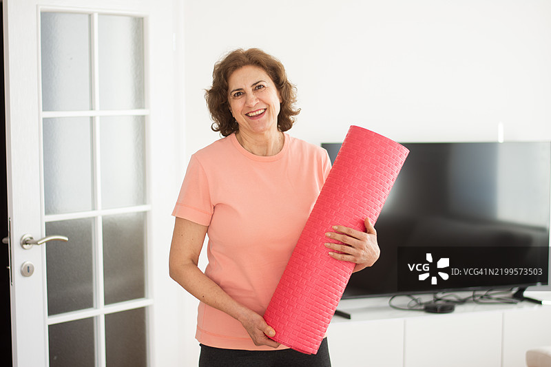 老年女性手持瑜伽垫图片素材