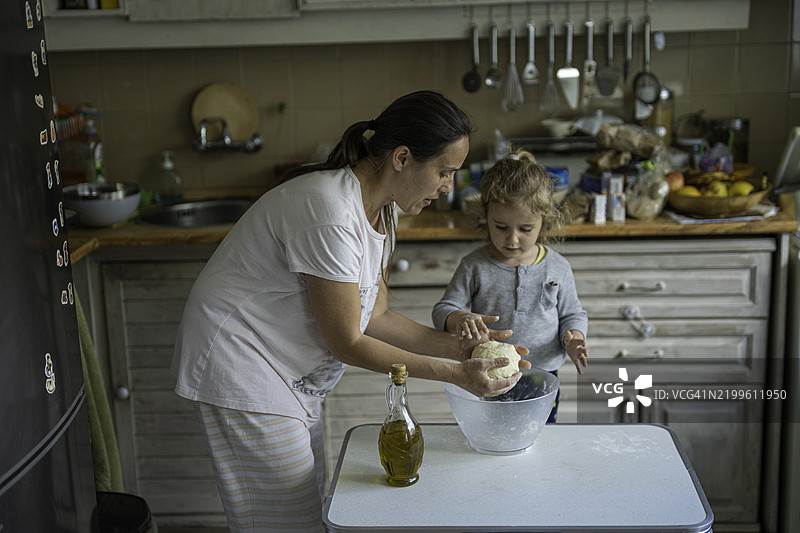 孩子帮助妈妈制作自制比萨面团。温馨的帮手图片素材