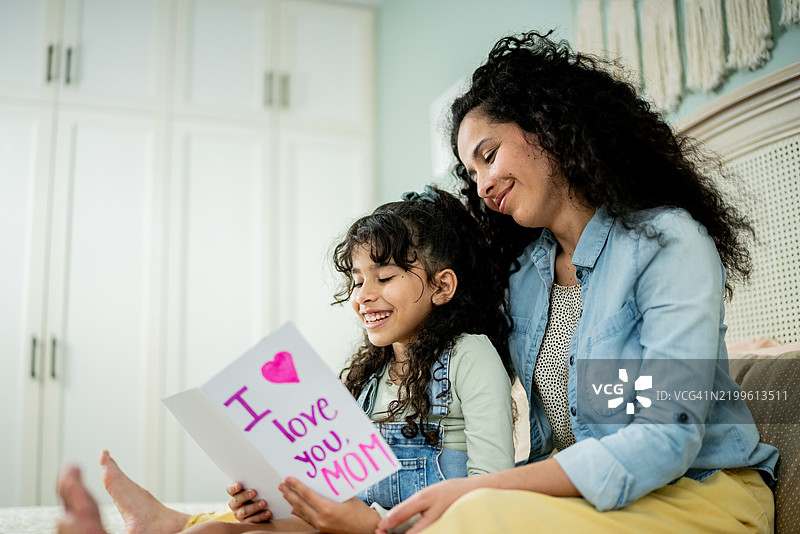 小女孩在家里给妈妈读信图片素材