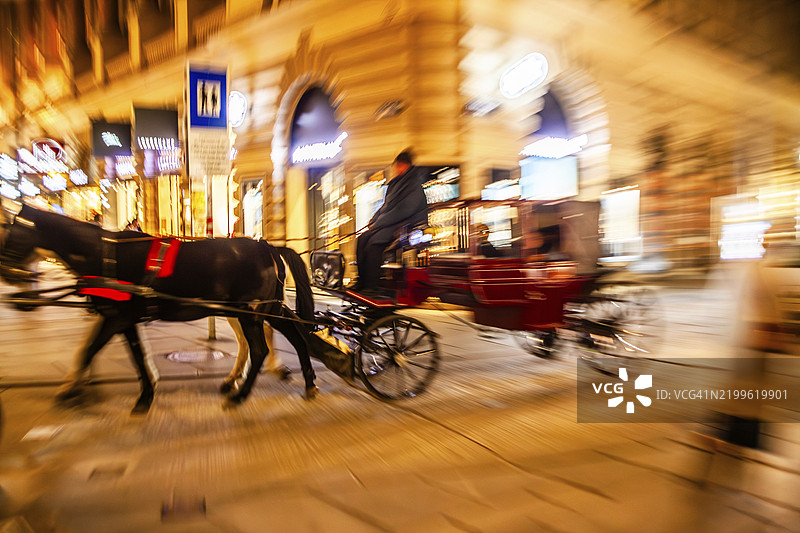 维也纳，奥地利，欧洲，夜间拍摄的马车行驶中图片素材