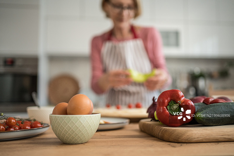 金发女性在家制作新鲜披萨图片素材