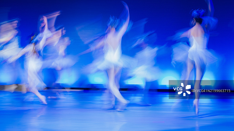 模糊的舞者在舞台上运动，蓝色灯光和柔和的阴影呈现出抽象风格。《胡桃夹子》，美国贝恩布里奇岛图片素材