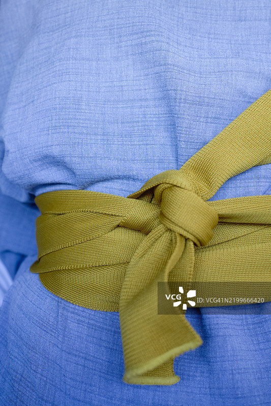 蓝色和服的特写，腰间系着黄色蝴蝶结，传统日本时尚文化，东京，日本图片素材