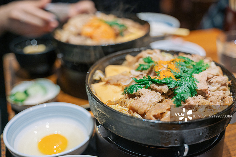 日式牛丼配味噌汤和配菜，摆放在木桌上图片素材