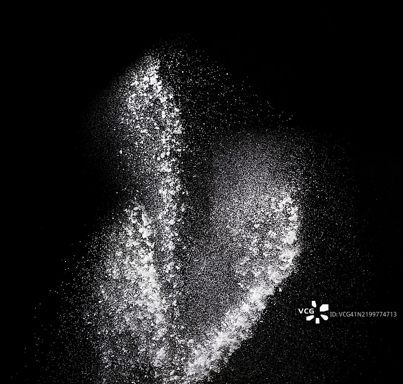 黑色背景上向上移动的尘埃颗粒爆炸。图片素材