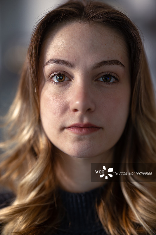 一位长着金色长发的年轻女性严肃地看着镜头图片素材