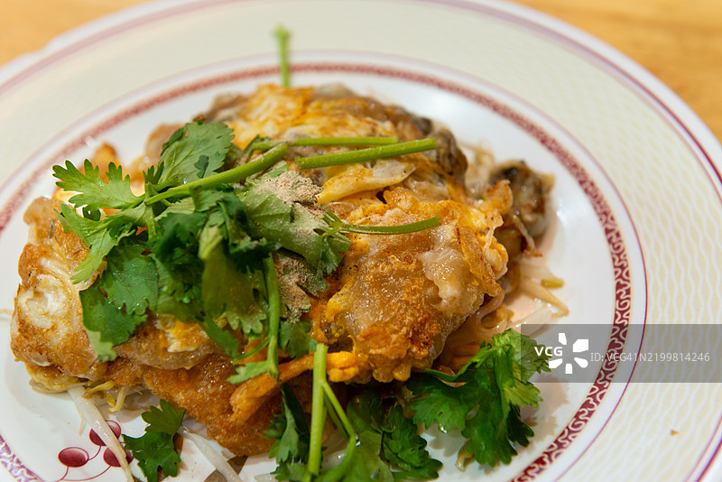 特写的泰式炸蚝煎蛋，配以香菜装饰图片素材