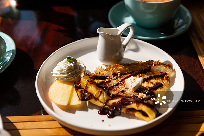 一盘配有浆果果酱和蜂蜜壶的煎饼早餐图片素材