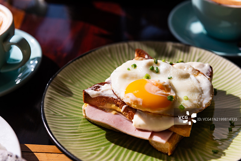 一盘包含鸡蛋和吐司的法式火腿奶酪三明治（Croque madame）早餐菜肴图片素材