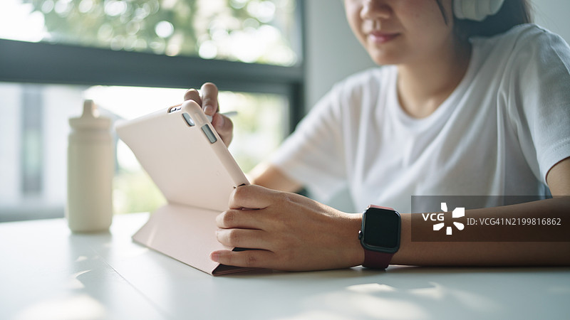 青少年女孩使用数字平板电脑。图片素材