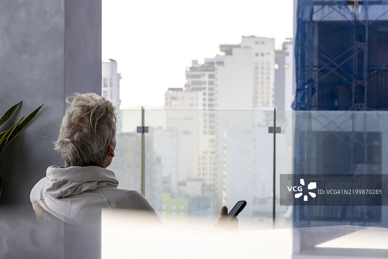 成熟男性在屋顶露台上使用手机图片素材