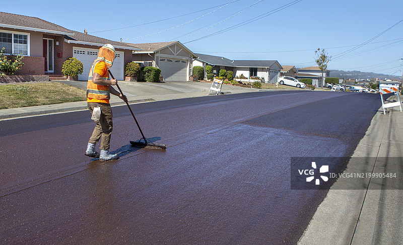 建筑维护工人在街道表面更换沥青材料图片素材