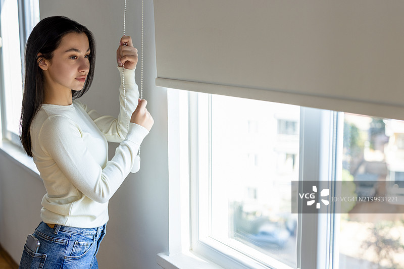 美丽的女人拉开窗帘图片素材