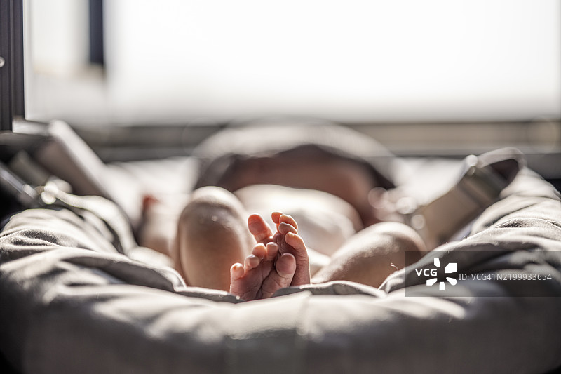 一个正在睡觉的新生儿，给新生儿日光浴图片素材