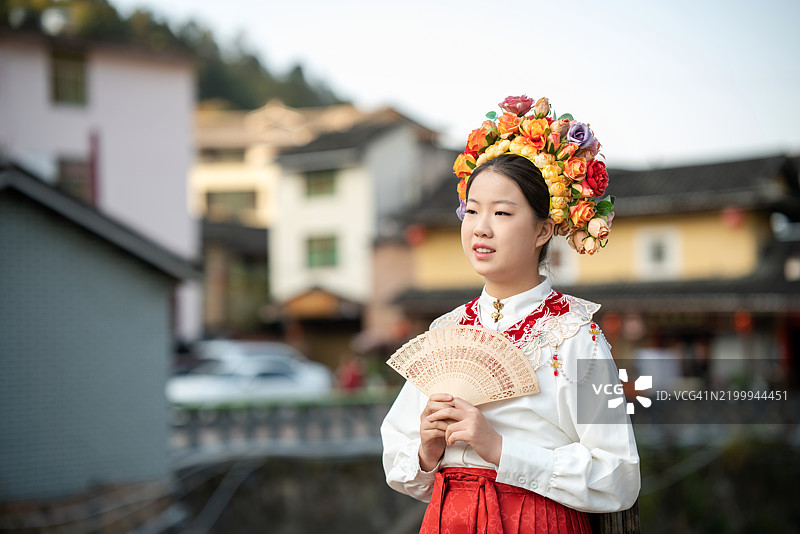 中国新年，穿着少数民族服饰的中国女孩在古老的村庄里图片素材