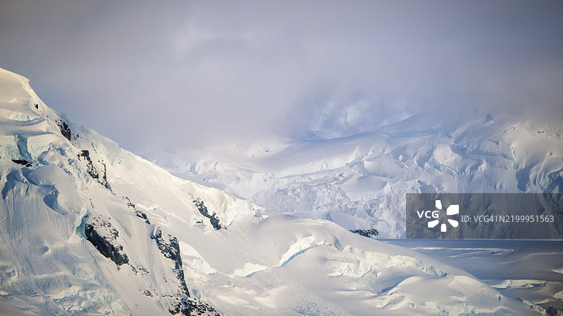 美丽的雪、云朵和南极洲丹科岛附近的戏剧性景观图片素材