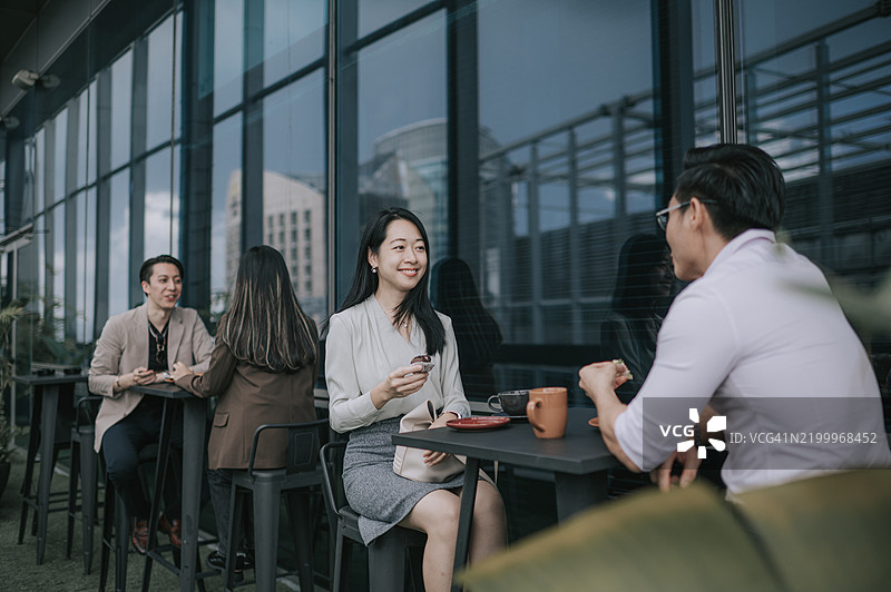 亚洲商务人士在露台咖啡馆享受茶歇图片素材