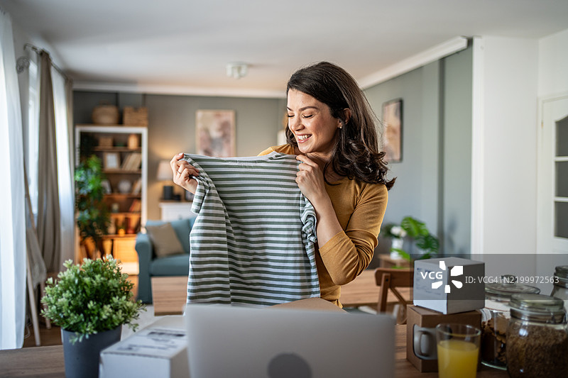 兴奋的年轻女性在家中打开包裹图片素材