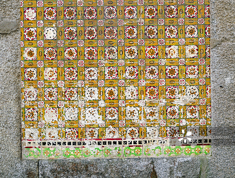 波尔图一座废弃房屋石质外立面上的风化和损坏的瓷砖。粗糙的纹理。阳光。自然色彩。图片素材