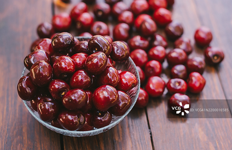 新鲜樱桃放在木桌上的碗里图片素材