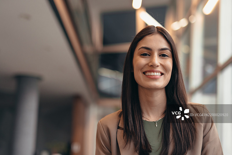 微笑的女商人在现代办公大楼内的肖像图片素材