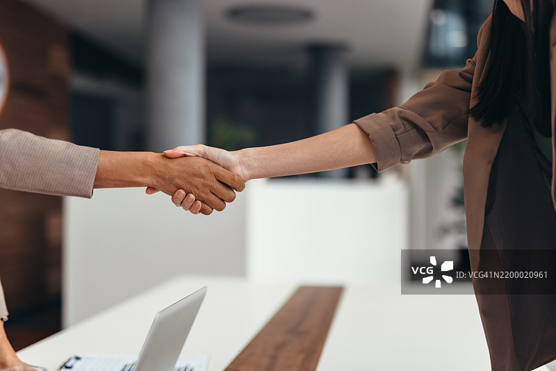 两位女商人在达成协议后握手。图片素材