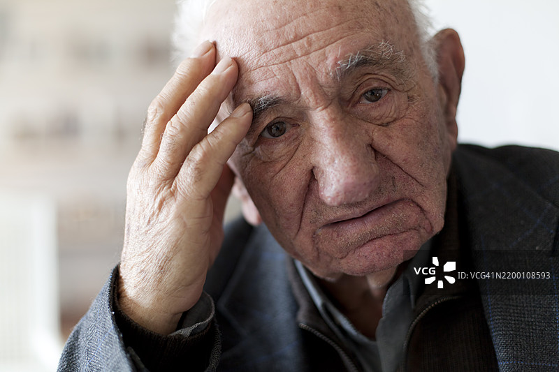 一位老年男子在安静的空间中表现出沉思的迹象图片素材