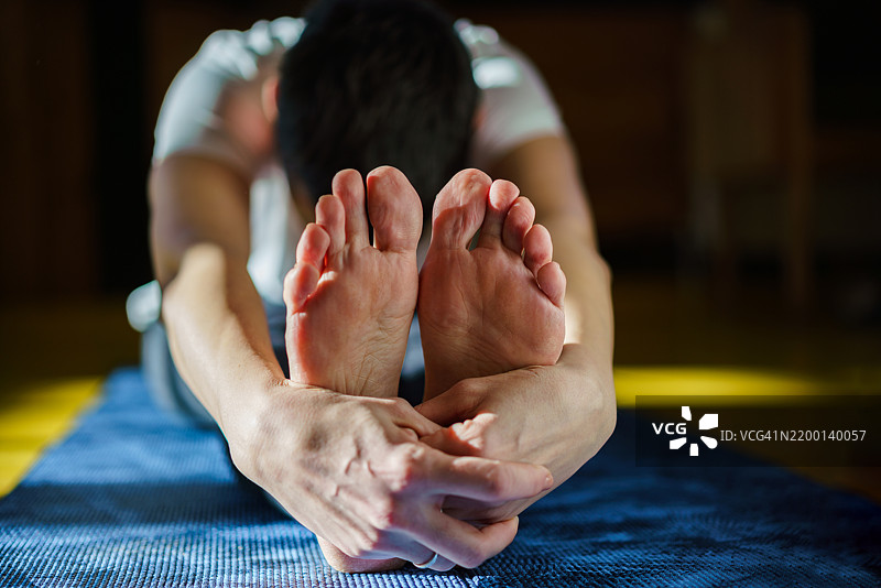 女人在瑜伽垫上拉伸身体图片素材