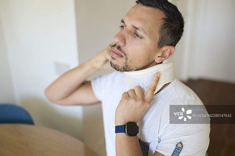 男子在家恢复期间调整颈托图片素材