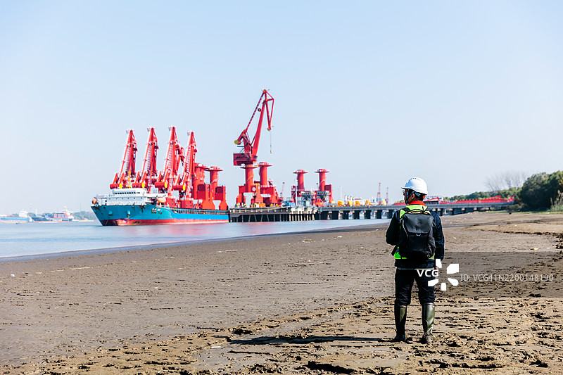 一名男性工程师在码头记录数据并指导工作图片素材