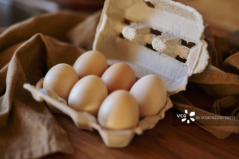 从上方俯视，桌面上有鸡蛋、纸箱、食材和新鲜农产品。适合餐点、甜点和早餐的食品，提供营养和蛋白质。图片素材