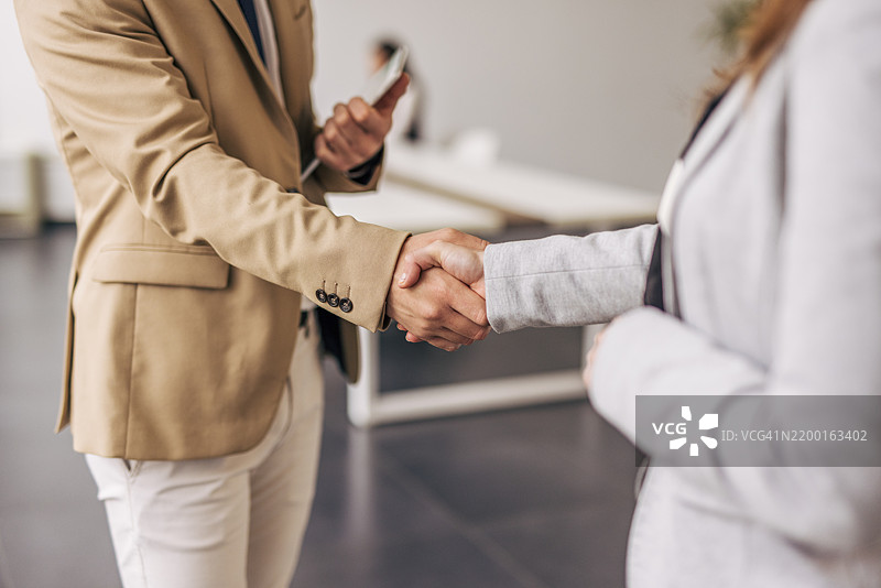 商务人士在办公室会议中握手交流图片素材