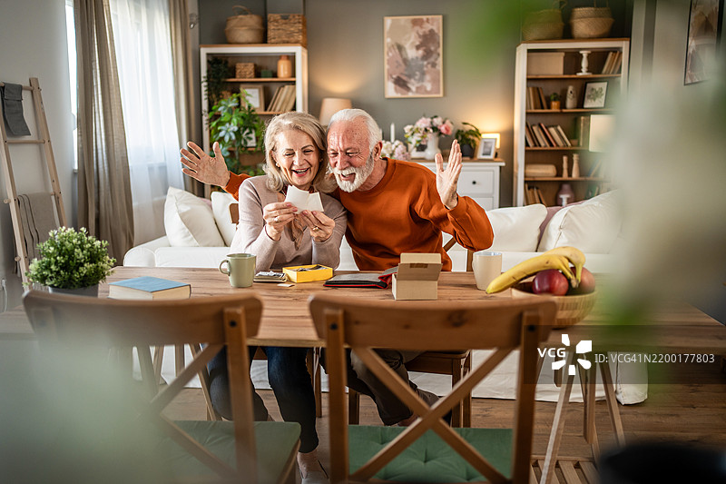 快乐的老年夫妇在怀旧的时刻中欣赏旧照片图片素材