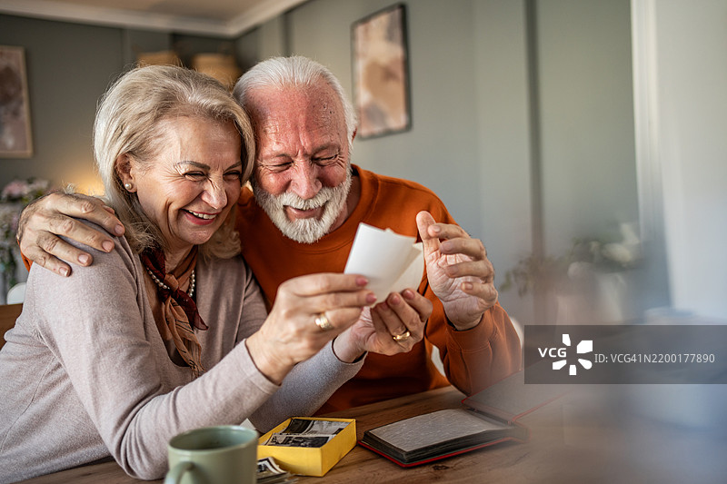 快乐的老年夫妇在怀旧的时刻中欣赏旧照片图片素材