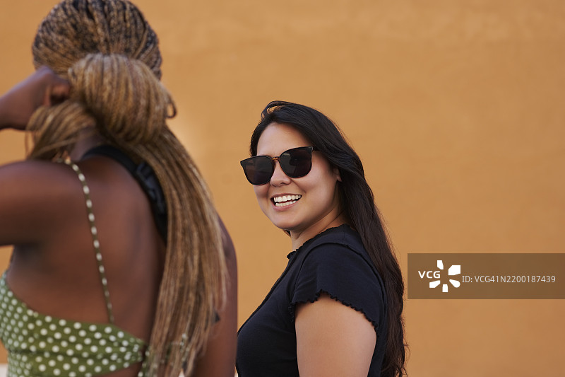 快乐的朋友们在城市中散步，享受周末的亲密时光，放松身心。旅行、墙面背景以及穿着夏季时尚的人的假期、冒险和假日生活。图片素材