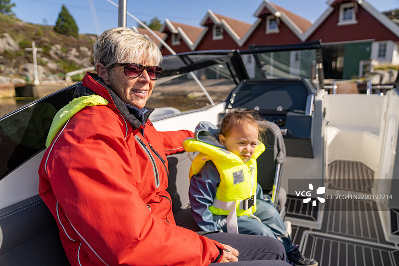 一位祖母和孙子在挪威奥斯特海姆的劳沃伊岛上进行划船冒险。图片素材
