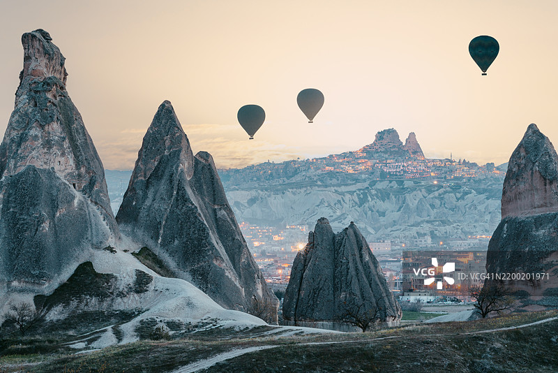 黎明时分，热气球飞越卡帕多奇亚小镇。旅游概念。图片素材