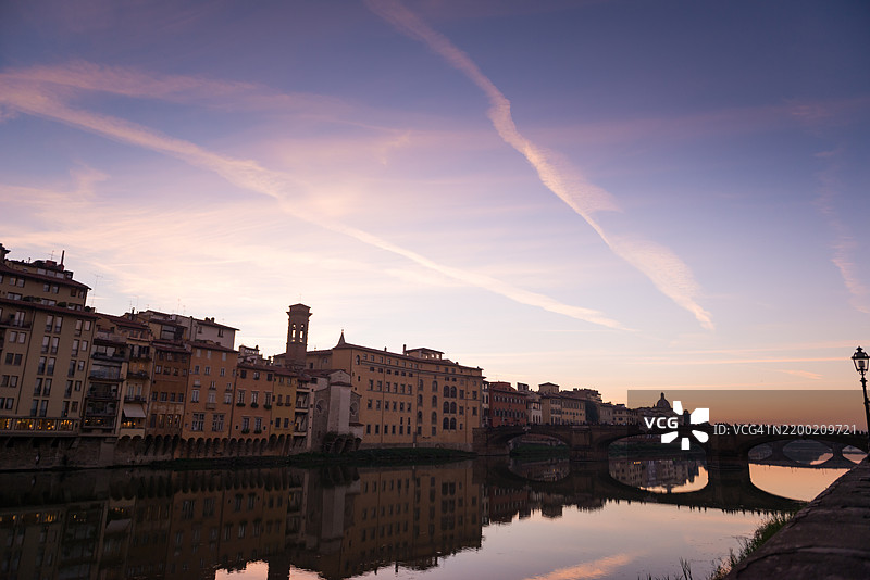 佛罗伦萨城市天际线的日落景色，圣三一桥的轮廓横跨阿诺河，水面上清晰的倒影。意大利佛罗伦萨。图片素材