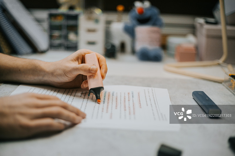 中景的西班牙裔男性学生在笔记本上写字图片素材