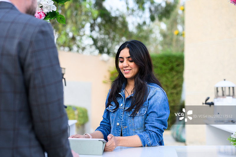 中东女性企业家在咖啡馆柜台使用数字平板接单图片素材