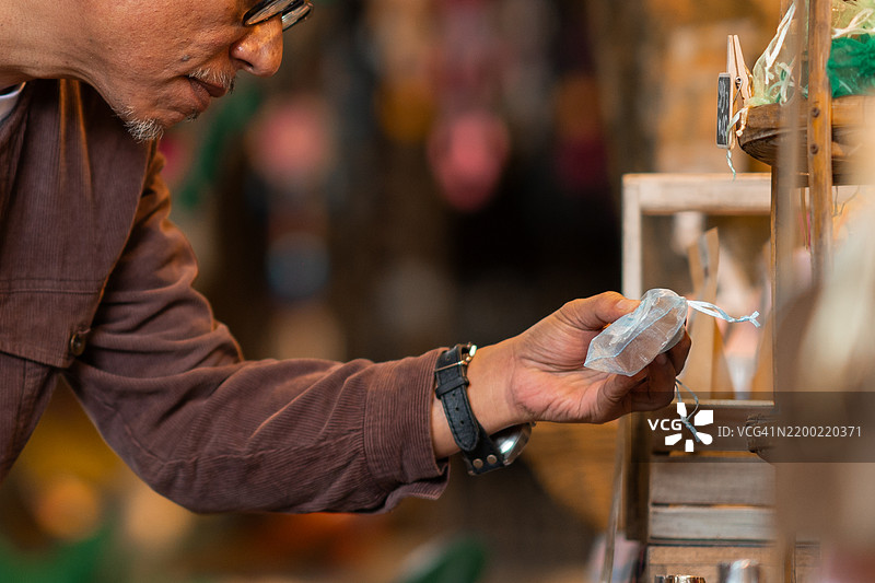 一位老年男游客悠闲地在当地市场漫步图片素材