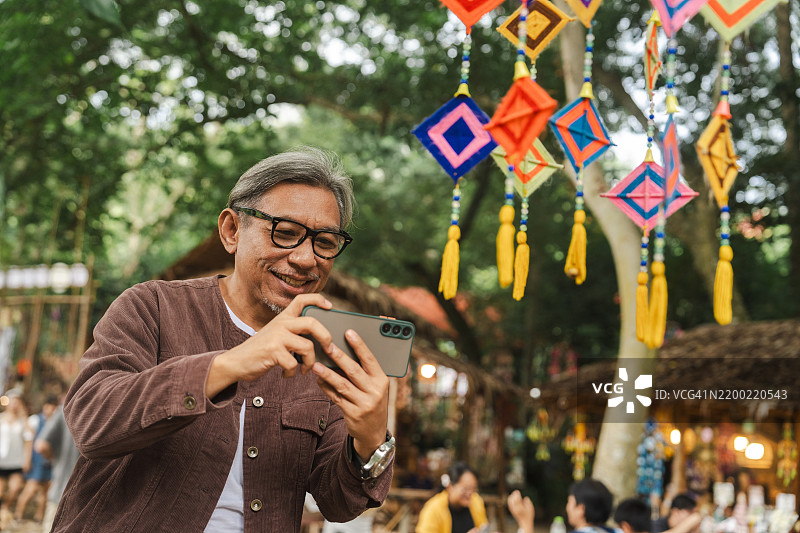 一位老年男性游客悠闲地在当地市场漫步图片素材