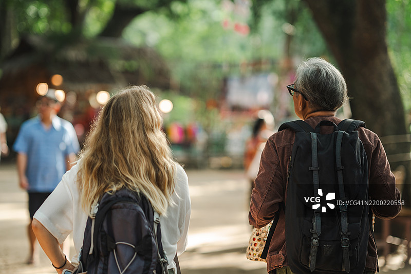一位外国女性游客在文化旅行中与一位老年男性合影图片素材