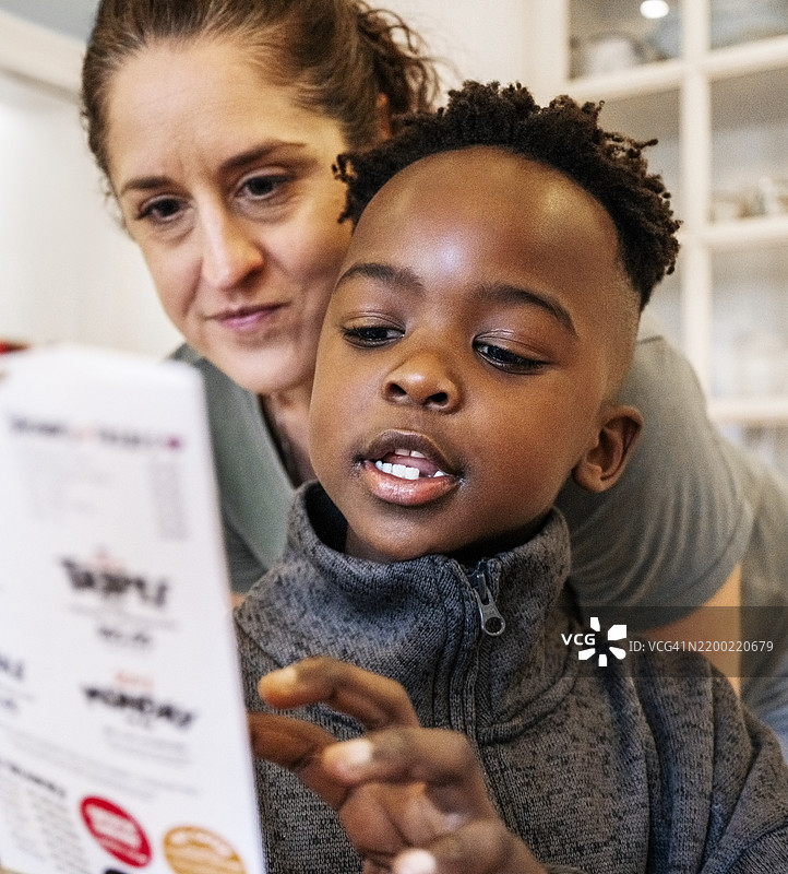 小男孩在家里和妈妈一起看书图片素材