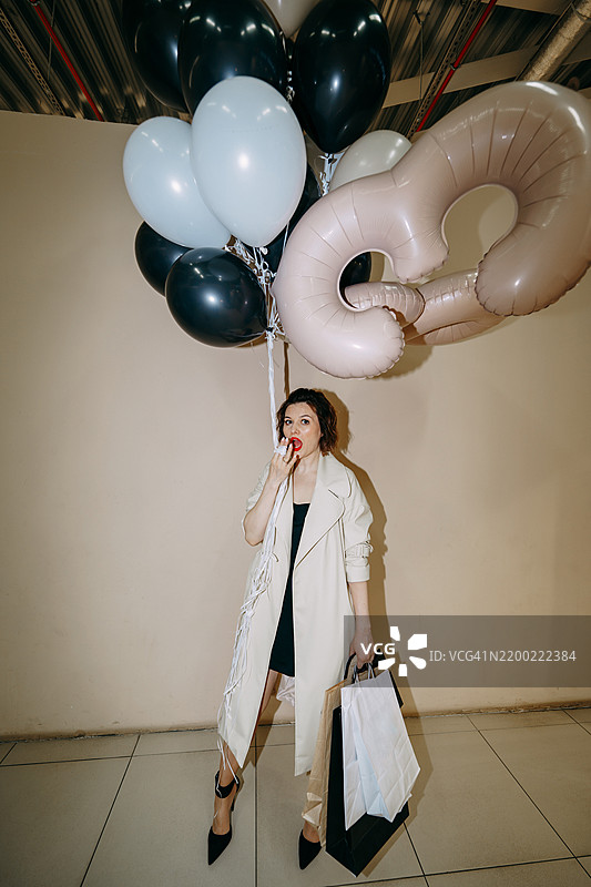 时尚女性手持购物袋和气球庆祝60岁生日图片素材