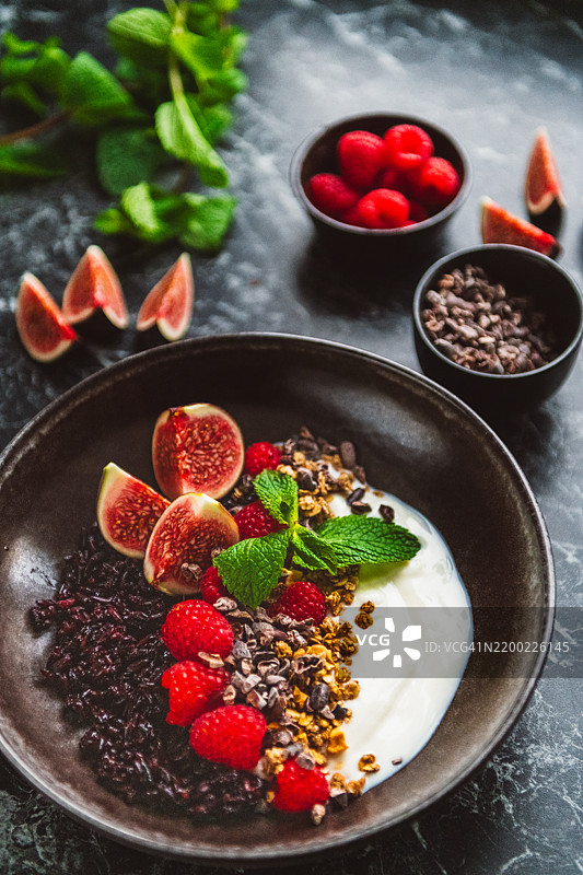 健康食品碗，包含黑米、酸奶、可可豆、燕麦片和新鲜水果图片素材